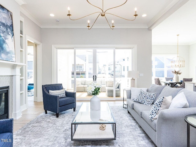 living room featuring a chandelier, recessed lighting, wood finished floors, a glass covered fireplace, and crown molding