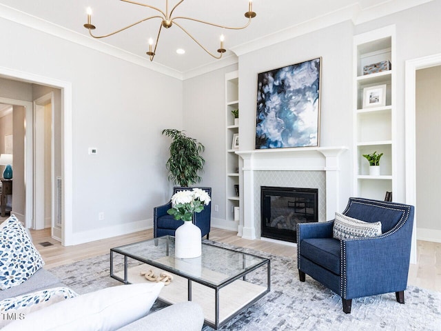 living area with built in shelves, a fireplace, baseboards, and wood finished floors