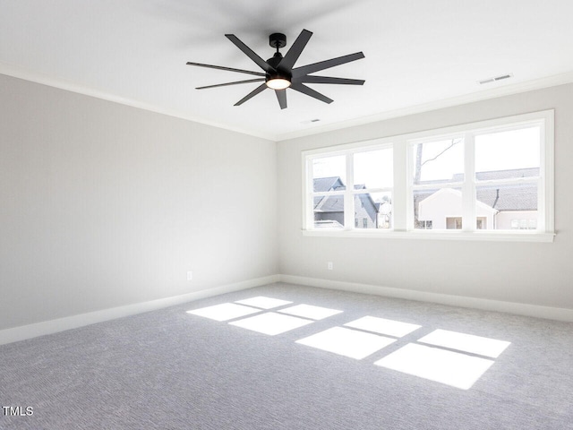 empty room featuring carpet, baseboards, and crown molding