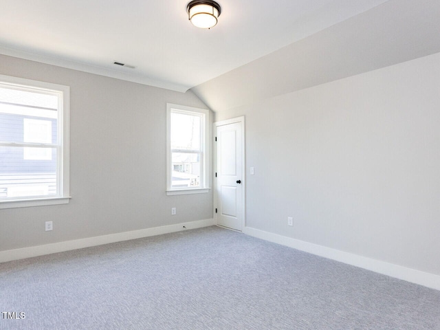 spare room featuring carpet floors, a wealth of natural light, visible vents, and baseboards