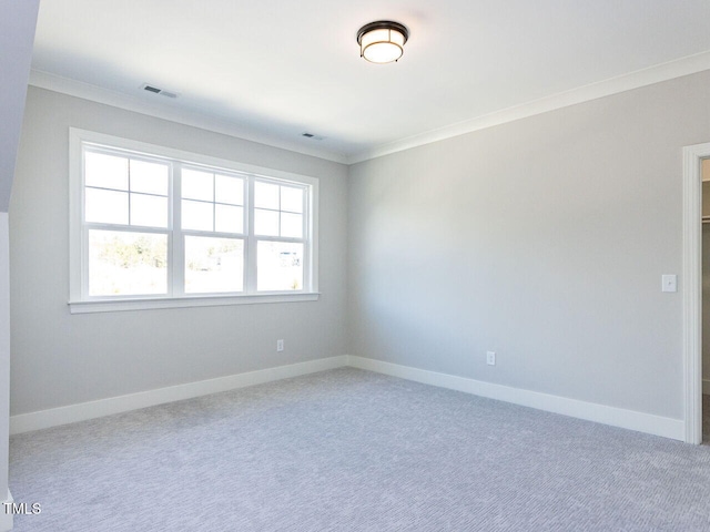 unfurnished room with ornamental molding, baseboards, visible vents, and carpet flooring