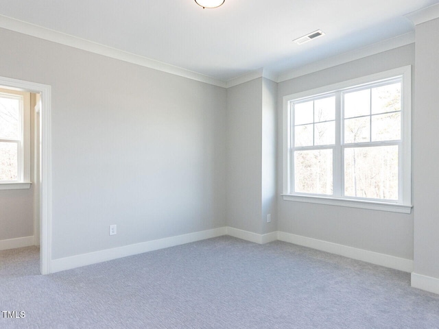 spare room featuring light carpet, baseboards, visible vents, and ornamental molding