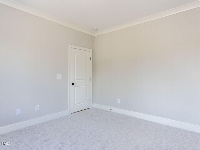 carpeted empty room with baseboards and crown molding