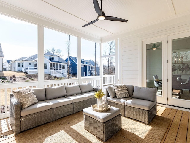 sunroom with a residential view and ceiling fan