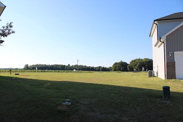 view of yard with a rural view and central AC unit