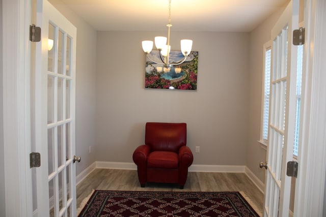 living area featuring a chandelier, light hardwood / wood-style flooring, and french doors