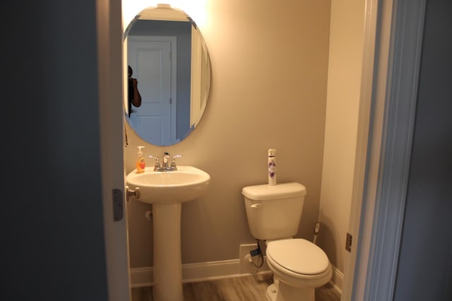 bathroom with hardwood / wood-style floors and toilet