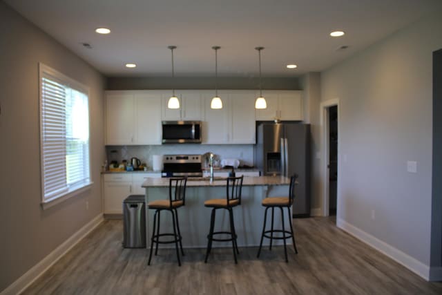 kitchen with white cabinetry, a center island with sink, and appliances with stainless steel finishes