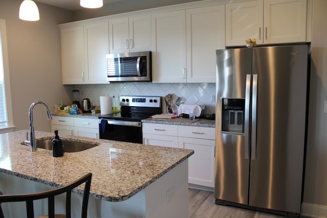 kitchen featuring backsplash, light wood-type flooring, sink, and stainless steel appliances