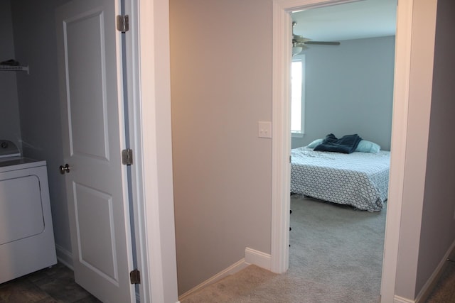 hall featuring washer / dryer and dark colored carpet