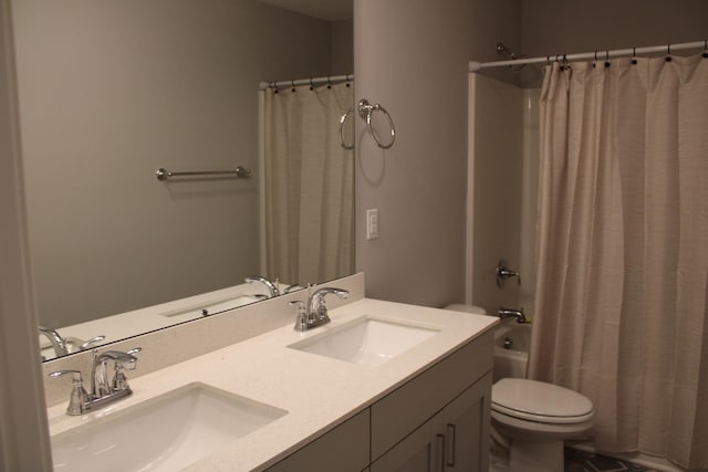 full bathroom with shower / bath combo, toilet, and double vanity