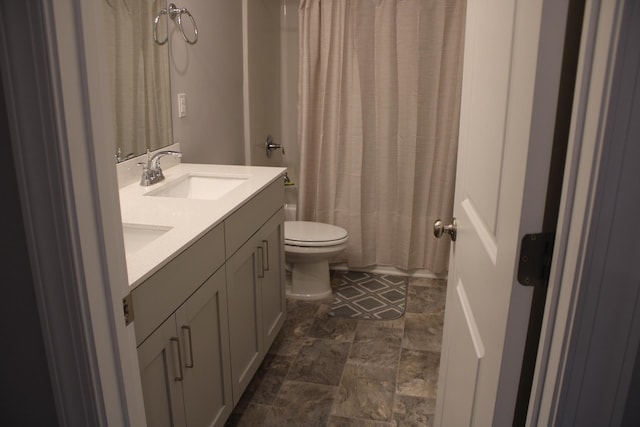 bathroom featuring tile flooring, toilet, and dual bowl vanity