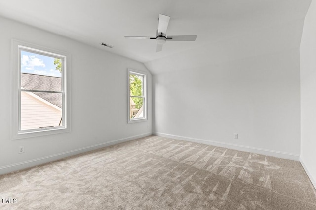 carpeted empty room featuring ceiling fan and vaulted ceiling