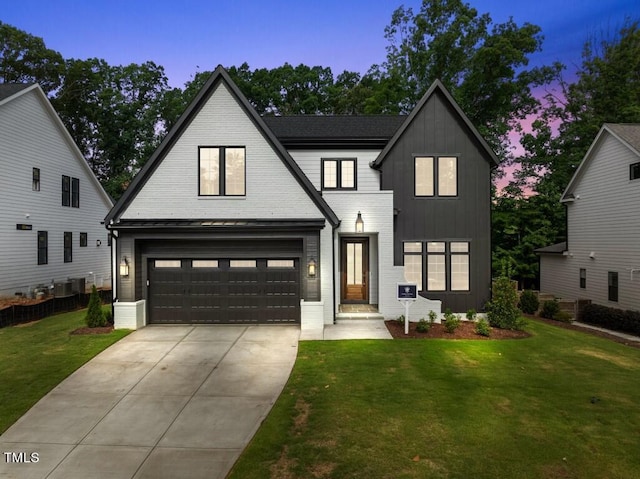 modern farmhouse with a lawn and a garage