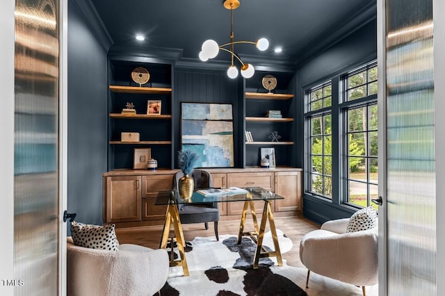 home office featuring built in shelves, light wood-type flooring, and crown molding