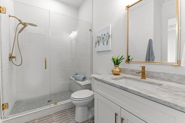 bathroom with vanity, toilet, and a shower with door