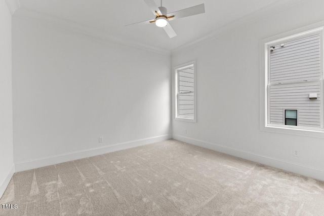 empty room with ceiling fan, light colored carpet, and ornamental molding