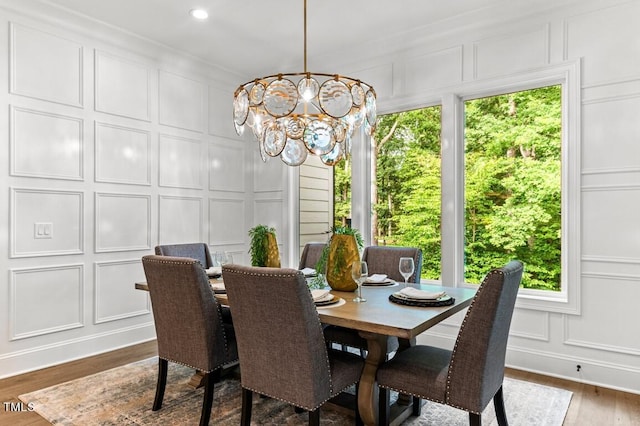 dining area with a notable chandelier, crown molding, and dark wood-type flooring