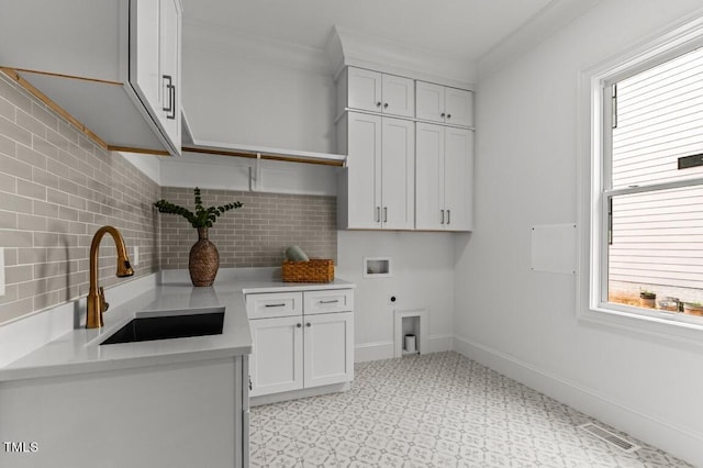 laundry area featuring cabinets, a wealth of natural light, electric dryer hookup, and sink