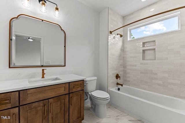 full bathroom featuring vanity, tiled shower / bath combo, and toilet