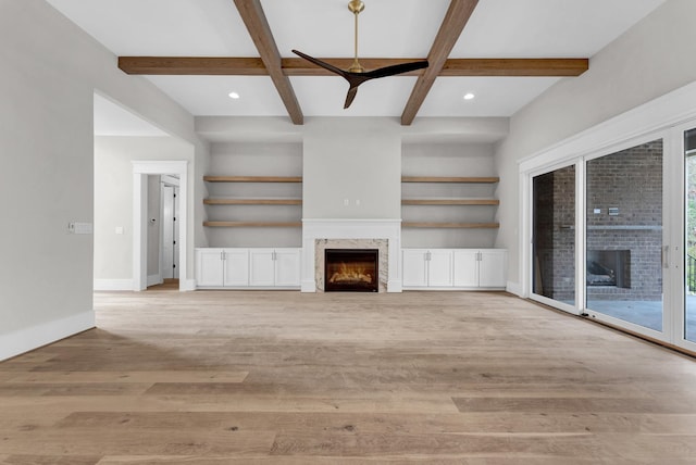 unfurnished living room with coffered ceiling, beamed ceiling, and light wood-type flooring