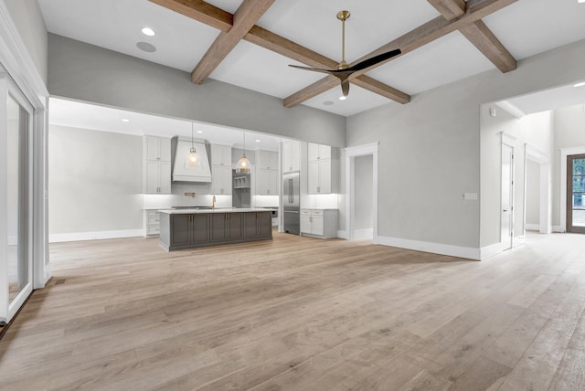 unfurnished living room featuring coffered ceiling and light hardwood / wood-style flooring