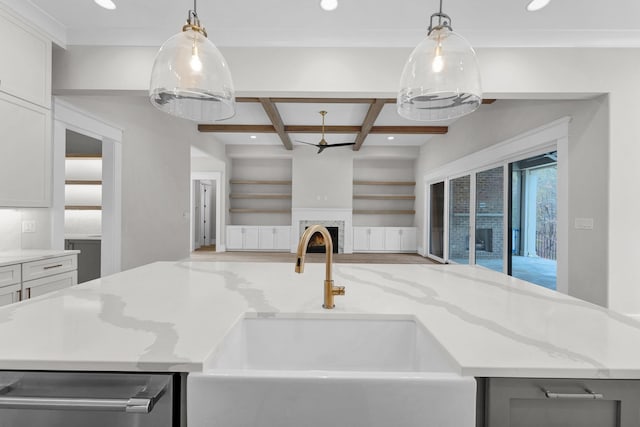 kitchen with coffered ceiling, hanging light fixtures, light stone countertops, and white cabinetry