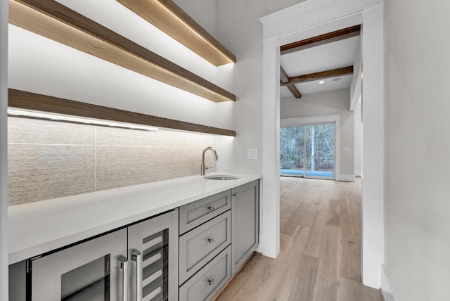 bathroom featuring vanity, beverage cooler, hardwood / wood-style flooring, and beamed ceiling