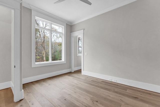 spare room featuring ornamental molding, ceiling fan, a healthy amount of sunlight, and light wood-type flooring