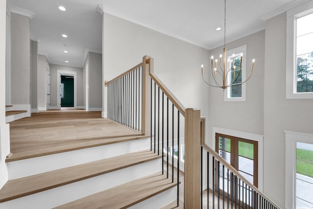 stairway featuring ornamental molding, a notable chandelier, french doors, and light wood-type flooring