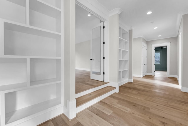 interior space featuring ornamental molding and light wood-type flooring