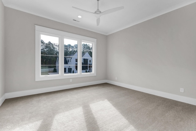 carpeted empty room with ceiling fan and crown molding