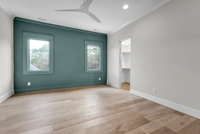 unfurnished room with ceiling fan, a wealth of natural light, and light hardwood / wood-style floors