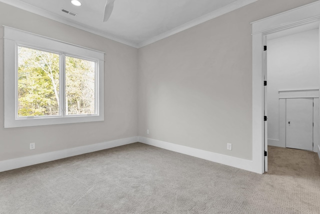 empty room featuring crown molding and light colored carpet