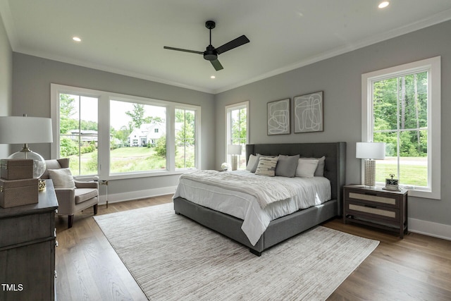 bedroom with ceiling fan, hardwood / wood-style flooring, and crown molding