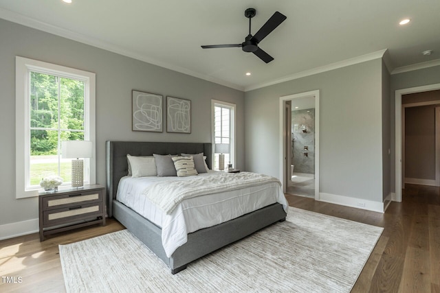 bedroom with multiple windows, ensuite bath, wood-type flooring, and ceiling fan