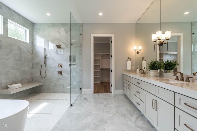 bathroom featuring vanity, a chandelier, and plus walk in shower