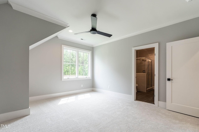 unfurnished bedroom with ornamental molding, light carpet, ensuite bathroom, and ceiling fan