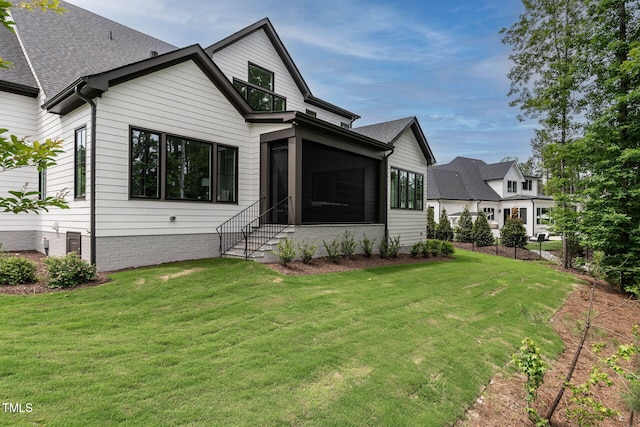 rear view of property with a sunroom and a lawn