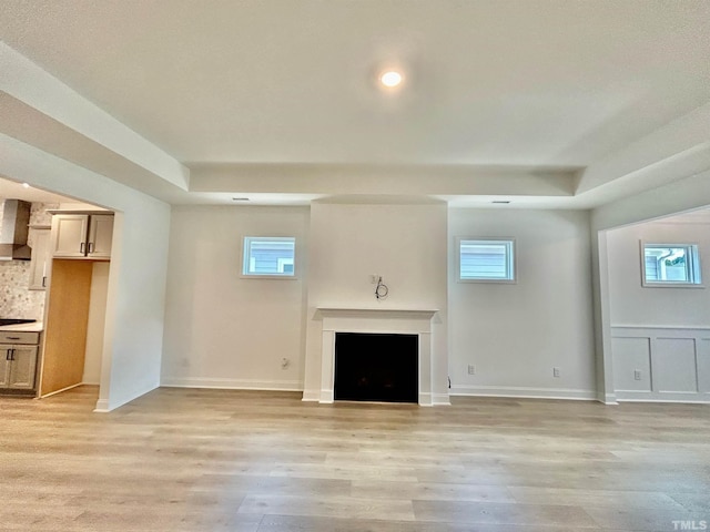 unfurnished living room featuring a wealth of natural light and light wood-type flooring