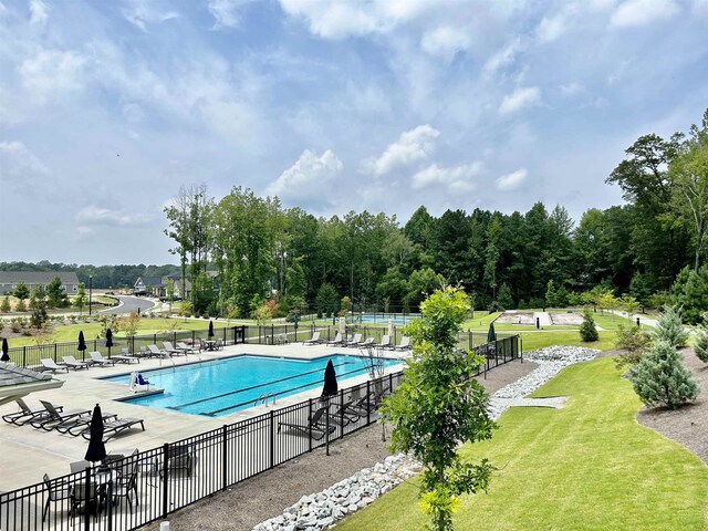 view of swimming pool with a lawn