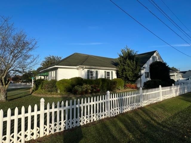 view of side of home with a yard