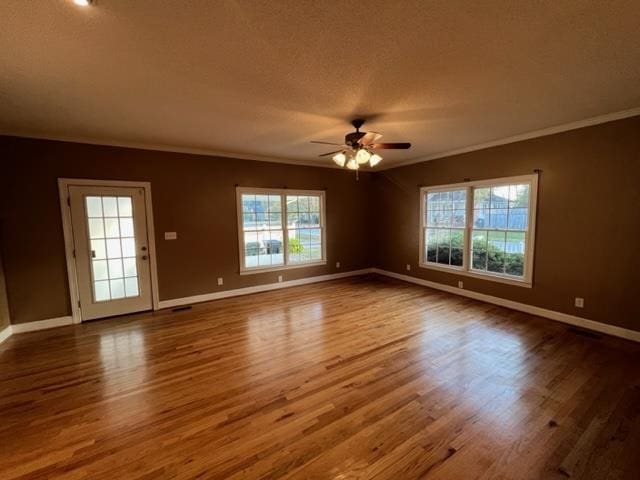 empty room featuring ceiling fan, hardwood / wood-style flooring, and ornamental molding