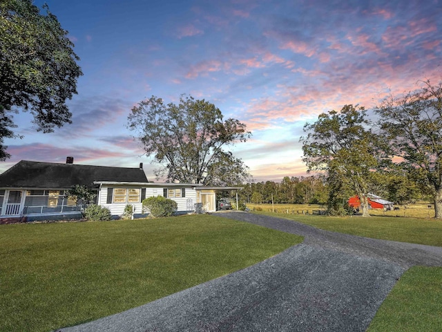 view of front of home featuring a carport and a lawn