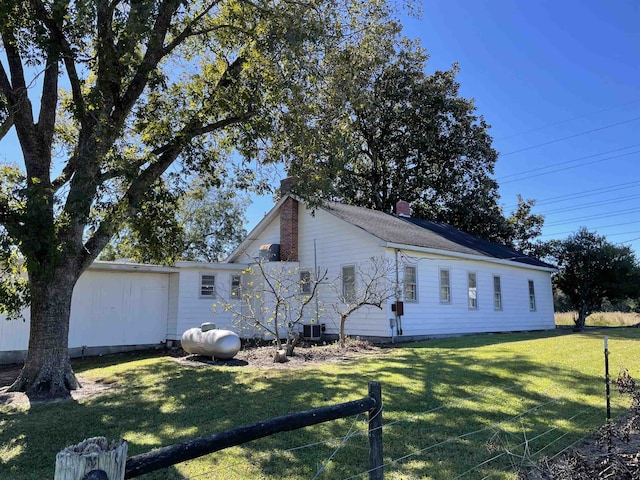 view of front of home with a front yard and central AC unit