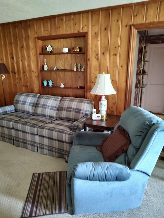 carpeted living room featuring wood walls