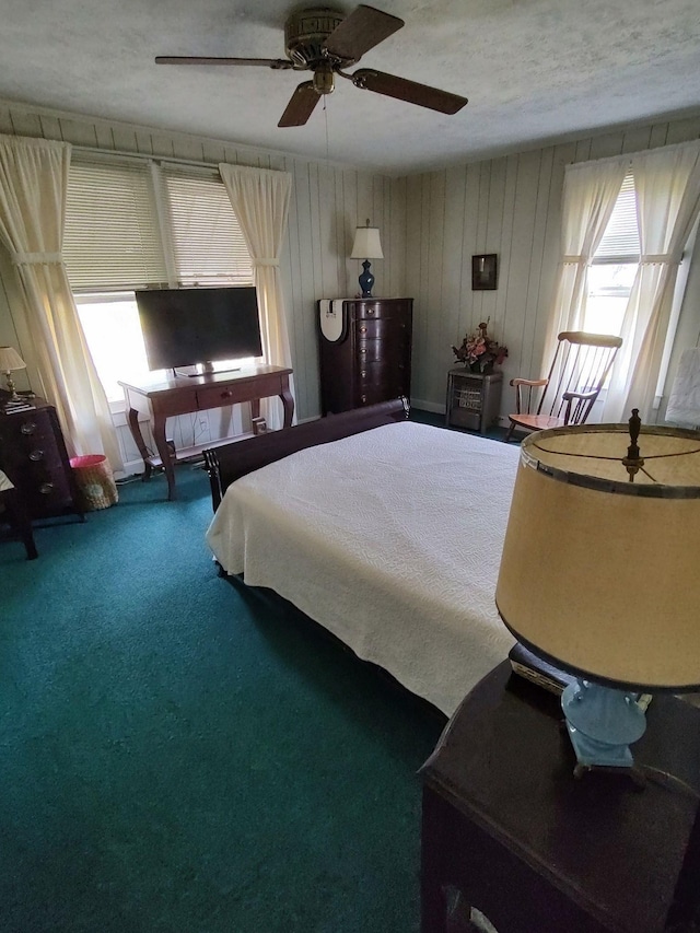 carpeted bedroom featuring multiple windows and ceiling fan