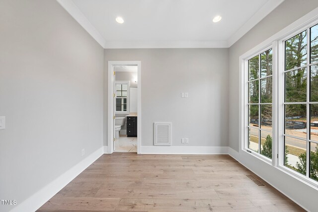 spare room featuring light wood-type flooring and ornamental molding