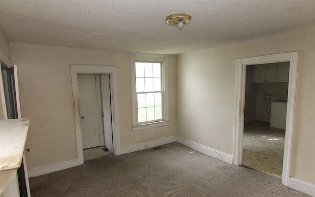 unfurnished bedroom featuring a textured ceiling, light carpet, and a closet