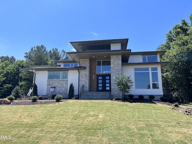 view of front facade with a front yard and stone siding